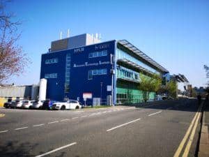 A blue building with a road in the foreground and a blue sky behind
