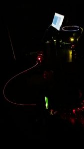 Optical fibres transmitting high powered laser light in a dark lab.