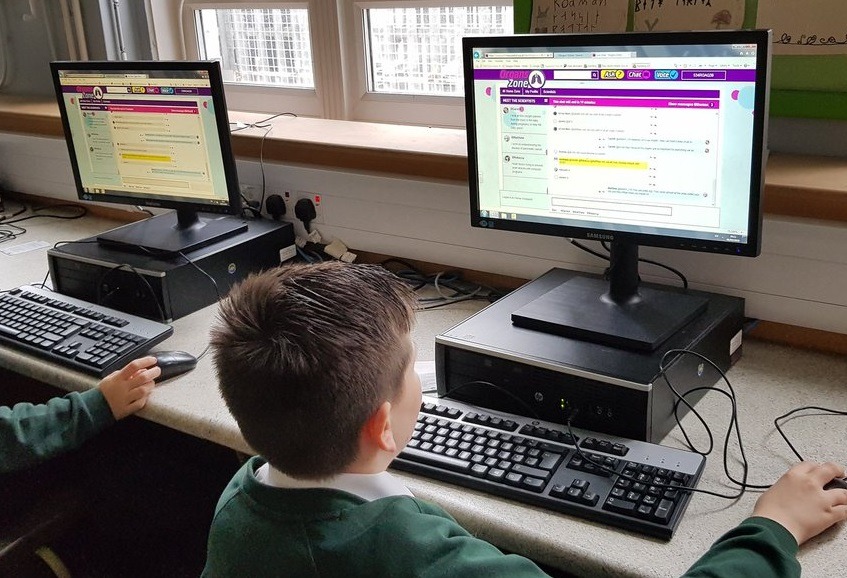 Decorative image of a young student at a computer. He is accessing the I'm a Scientist website and looks very engaged.
