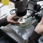 Scientist using micromanipulator to inject fish egg.
