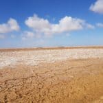 a photo of the Sahara desert, with salt in the middle distance