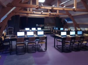 Picture of a school classroom filled with around 20 computers, all set up and ready for language research. 